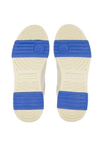 Weiße Sneakers mit blauer Gummisohle. Die Sohle verfügt über Rillen und kreisförmige Akzente, mit der Marke "Sergio Tacchini" an der Seite.