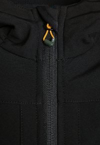 Zwarte zip-up jack met een soepele textuur, een contrasterende rits en een verstelbare capuchon met een trekkoord. Accenten zijn een groene toggle.
