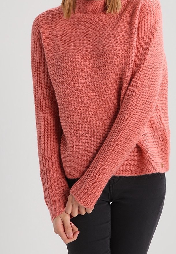 Pull tricoté en corail doux avec un col haut, une coupe ample et un motif texturé. Poignets et ourlet côtelés, fente latérale, et marquage minimaliste.