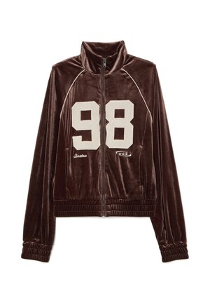 Bruine fluwelen ritsjack met hoge kraag, met het nummer "98" in crèmekleur en "Boston" geborduurd eronder. Geribbelde manchetten en zoom.