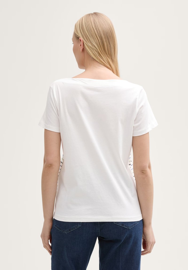 T-shirt en coton blanc avec une coupe décontractée, un col rond et des manches courtes. Présente un motif contrastant sur les côtés et une texture lisse.