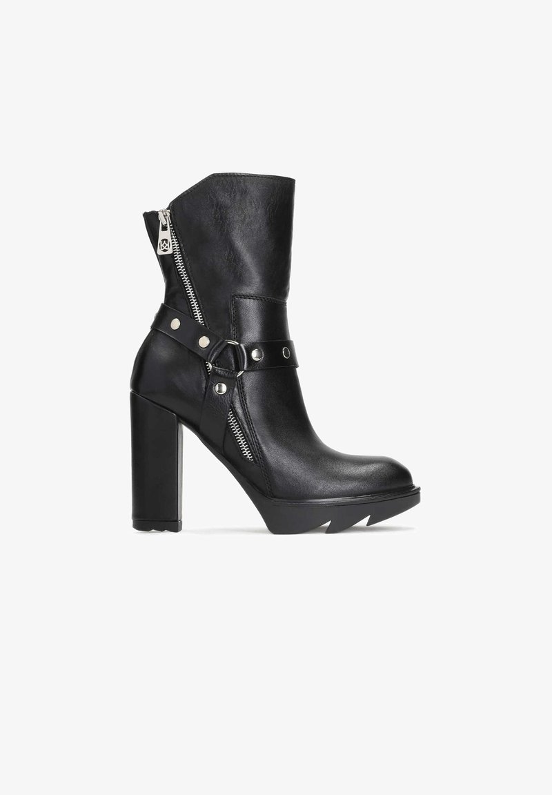 Black leather ankle boot with a high block heel, side zipper, and decorative strap with studs. Features a sharp, textured toe.