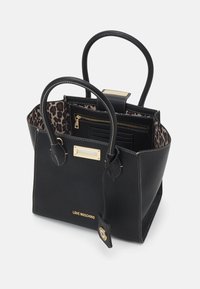 Svart läder tote-väska med strukturerad yta, gyllene detaljer, foder med leopardmönster och ett innervarut som har dragkedja. Har dubbla bärhandtag och tag.