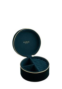 Round jewelry case in dark green velvet with gold zipper. Inside features a divided compartment and slots for rings. "FABLE" embossed inside.