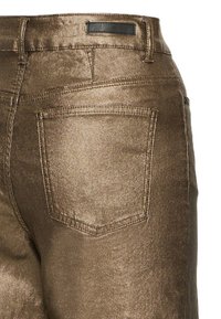 Jeans bronzo metallizzato con un design aderente, tasche anteriori e posteriori e una texture liscia e lucida con dettagli di cucitura discreti.