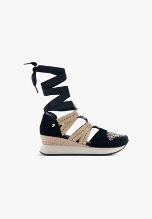 Baskets compensées noires avec des brides tissées beiges, détail de la semelle, et de longs lacets noirs entourant la cheville, vues de profil droit sur fond blanc.