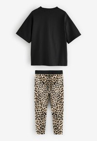 Svart t-shirt med kort ärm i kombination med beiga leggings med svart leopardmönster. Mjukt tyg med en avslappnad passform.
