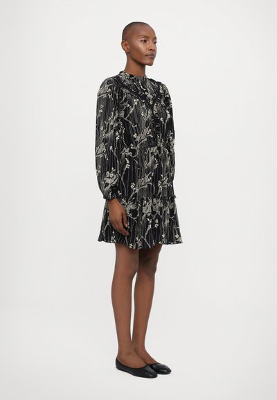 Vestido negro con estampado floral, mangas largas, cuello alto, acentos de volantes y falda de capas. Tejido suave y diseño fluido.
