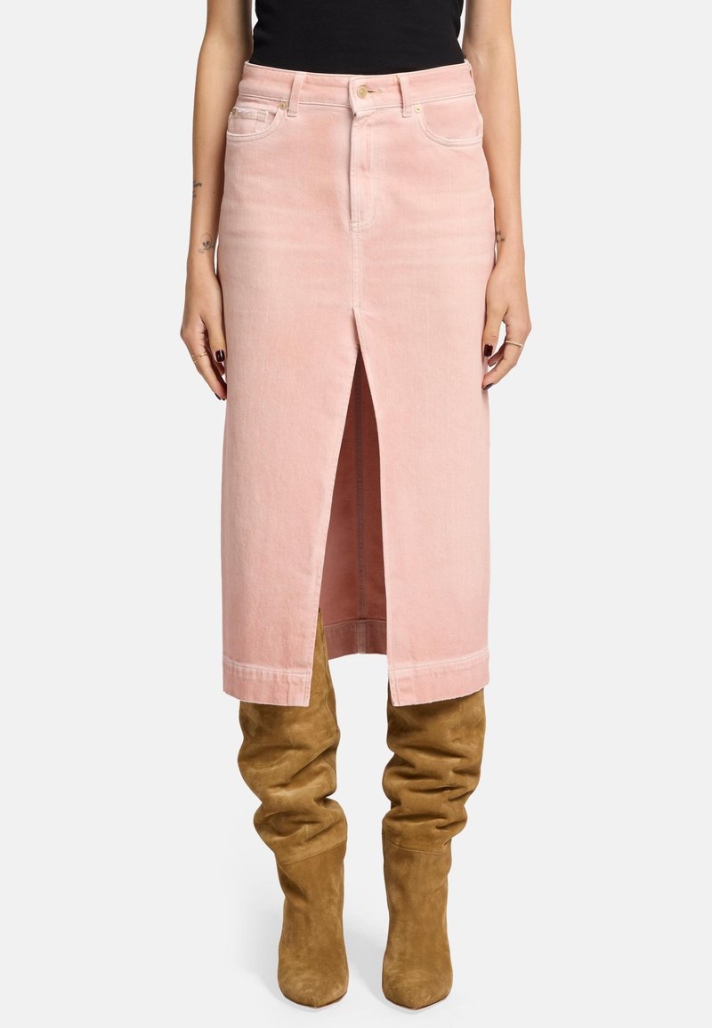 Jupe en denim rose clair avec une fente avant, taille haute et design standard à cinq poches, associée à des bottes en daim beige arrivant au genou.