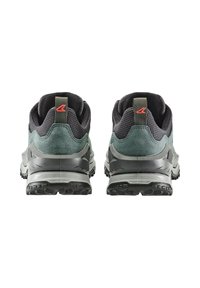 Trail-Schuhe mit einem Obermaterial aus dunkelgrünem Wildleder und Mesh, grauer Zwischensohle, multidirektionalem Profil und einem roten Akzent in der Nähe der Ferse.