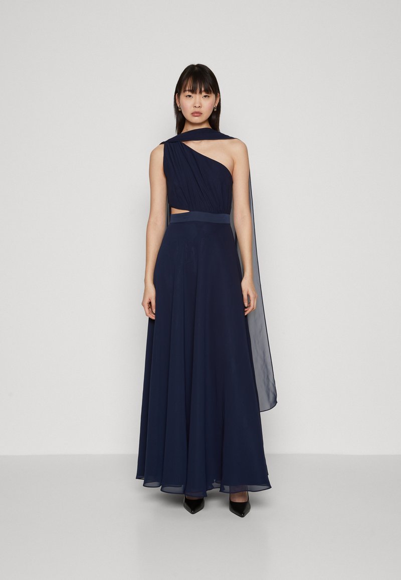 Robe navy avec une épaule asymétrique, tissu fluide, détail découpé à la taille et une longue cape translucide.
