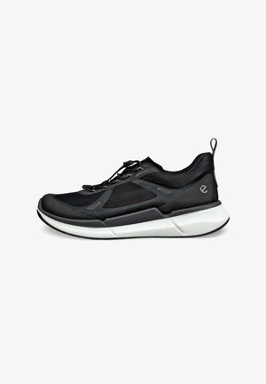 Schwarzer Sportschuh mit strukturiertem Obermaterial, flachen Schnürsenkeln und einer gepolsterten weißen Sohle; verfügt über eine Hinterziehschlaufe und dezente Branding-Akzente.