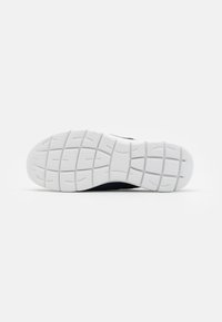 White rubber sole with textured grip patterns, part of a navy shoe, featuring a smooth upper material for comfort and support.