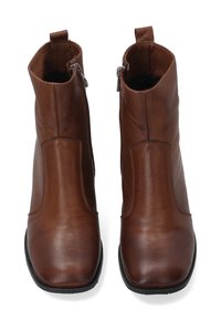 Pár hnědých kožených kotníkových bot se bočními zipy, čtveratými špičkami a černými podrážkami, zobrazených shora na bílém pozadí.