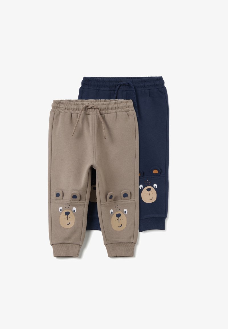 Twee paar joggingbroeken voor kinderen, één beige en één marineblauw, elk met elastische taille, trekkoordjes en berengezichten op de knieën.