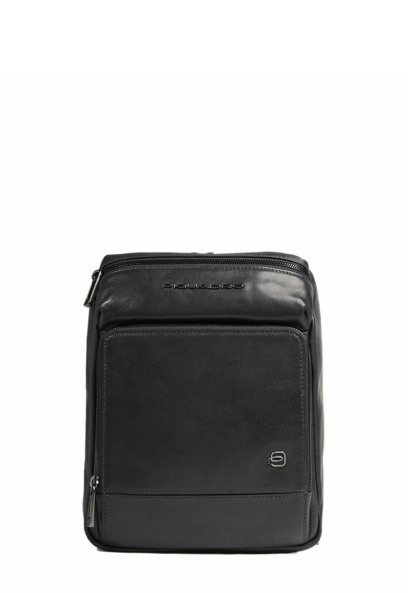 Zaino in pelle nera con superficie texture, dotato di zip superiore, tasca frontale e una sottile marchiatura sulla parte anteriore. Forma pulita e rettangolare.