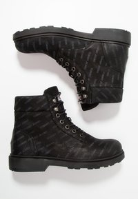 Černé kotníkové boty s texturovaným povrchem a opakovaným vzorem loga, kovovými očky a robustní gumovou podrážkou pro dobrý grip.