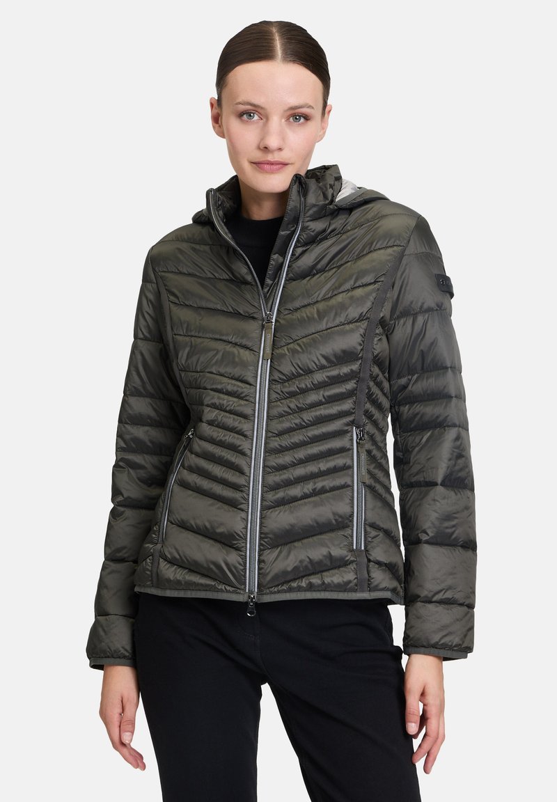 Izolowana kurtka w ciemnozielonym kolorze, z wzorem w chevron, zamek błyskawiczny z przodu i kapturem. Lekki materiał z subtelnym połyskiem oraz dwie boczne kieszenie.