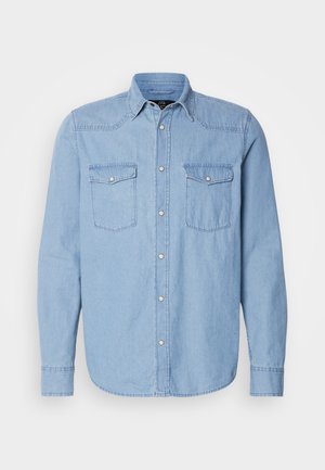 Lichtblauwe denimshirt met lange mouwen, twee borstzakken, knoopsluiting aan de voorkant en een klassieke kraag met witte stikseldetails.