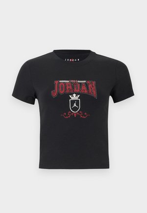 Svart T-skjorte med korte ermer med rød "1984 Jordan"-tekst, hvit krone, skjold med Jumpman-logo og dekorativ rød ornament under.