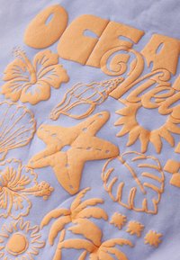 Tissu violet clair présentant des motifs marins orange en relief, comprenant des fleurs, des coquillages, une étoile de mer et des feuilles. Textures variées.