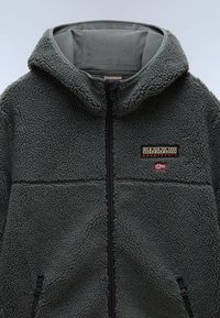 Felpa con zip grigia in pile con superficie texturizzata, dettagli neri e logo del marchio sul petto, dotata di cappuccio con coulisse e tasche laterali.