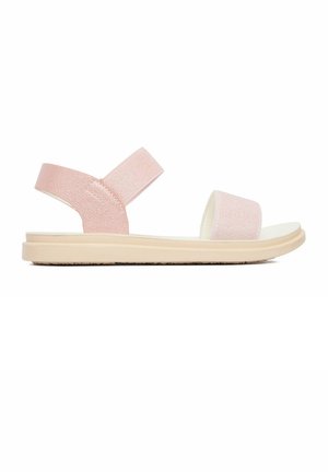 Jasnoróżowa płaska sandałka z elastycznymi paskami na kostkę i palce, beżowa, miękka podeszwa, zaprojektowana do noszenia codziennego.