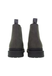 Pár tmavě šedých kotníkových bot s tlustými černými podrážkami, viditelným zadním švem a značkovými poutky na patě.