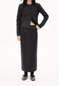 Ciemnoszary dzianinowy kardigan z okrągłym dekoltem i zapięciem na guziki, połączony z dopasowaną długą spódnicą. Tkanina o fakturze i przylegający krój.