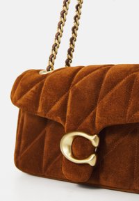 Brown suede quilted handbag with gold chain strap and large gold metal "C" clasp on front flap.