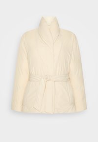 Krämfärgad vadderad jacka med bälte i midjan, hög krage och två framfickor. Mjuk textur med slät yta.