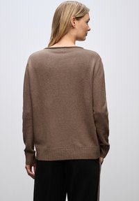 Brauner Strickpullover mit lockerer Passform, geripptem Saum und langen Ärmeln. Die weiche Textur erhöht den Komfort. Die Rückansicht zeigt einen weiten Ausschnitt.