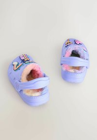 Svetle fialové dřeváky s měkkou, barevnou kožešinou, zdobené hravými 3D dekoracemi duhy, mraků a animované postavy.