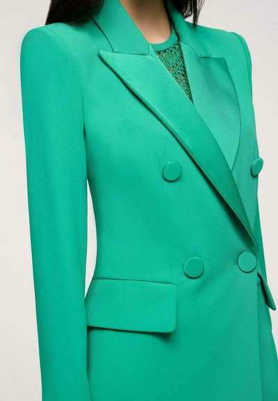 Turquoise groene dubbelzijdige blazer met een slank ontwerp, gepolsterde schouders en ronde knopen. Heeft een gladde textuur en scherpe revers.