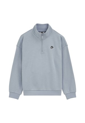 Lyseblå sweatshirt med halvlynede krave, ribbede manchetter og linning. Har et lille sort broderet logo på venstre bryst.
