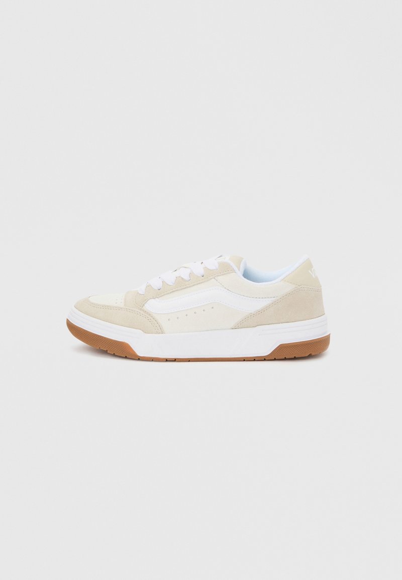 Μπεζ και λευκό αθλητικό παπούτσι χαμηλού προφίλ με λευκά κορδόνια και σόλα από καουτσούκ χρώματος σοκολάτας, εμφανιζόμενο από την εξωτερική πλευρά σε απλό φόντο.