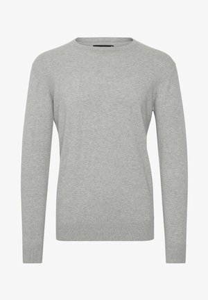 Vaaleanharmaa neule, joka on valmistettu pehmeästä neuloksesta ja jossa on pyöreä pääntie ja pitkät hihat. Ribbaatut hihansuut ja helma antavat tiukemman ilmeen.