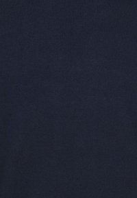 Marineblauwe, ribgebreide stof met een zachte textuur; heeft een gelijkmatige, consistente weving zonder zichtbare patronen of accenten.