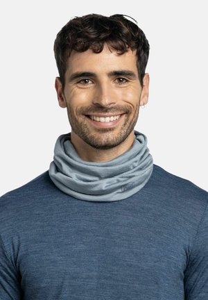 Light blue, soft fabric neck gaiter worn over a navy blue shirt. Features a smooth texture and a logo accent on the side.