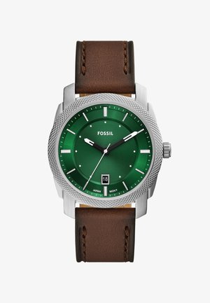 Montre à cadran vert avec boîtier en argent et bracelet en cuir brun, dotée d'un affichage de date, d'une lunette texturée et de repères horaires blancs.
