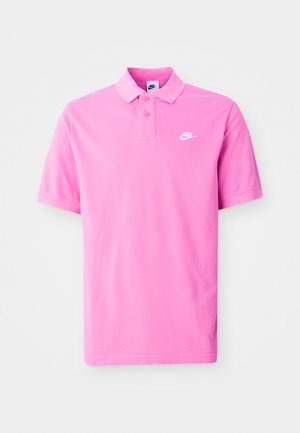 Camisa polo Nike rosa, de manga corta, con cuello clásico, tapeta de dos botones y un logo blanco en el lado izquierdo del pecho. Tejido de textura suave.