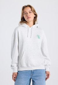 Light gray oversized hoodie in cotton blend with a front pouch pocket, drawstring hood, and a teal graphic design on the chest.