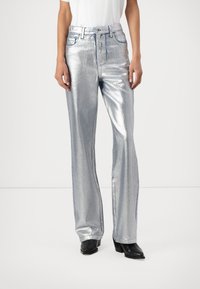 Pantaloni metallici argento con design a gamba svasata, caratterizzati da uno stile classico a cinque tasche e una chiusura con zip. Texture liscia e finitura lucida.