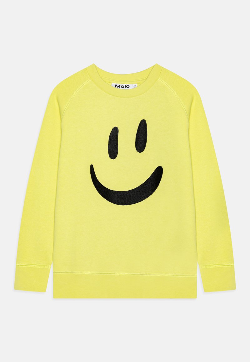 Gul genser laget av myk stoff med et stort svart smiley-ansikt grafikk i sentrum. Klassisk rund hals og ribbede mansjetter.