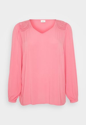 Pink long-sleeve blouse with a V-neckline, featuring textured accents on shoulders and soft, flowing fabric. Straight cut and loose fit.