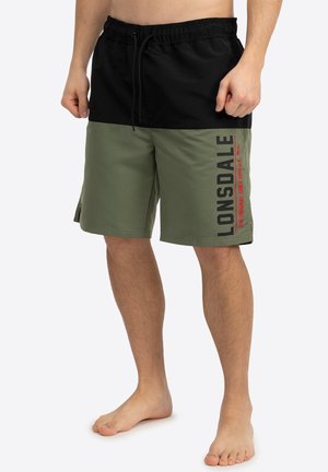 Black and olive green swim shorts with an elastic waistband, drawstring, and Lonsdale branding in red and black on the side.