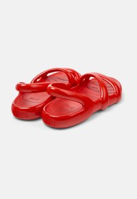 Red rubber clogs with a smooth, glossy texture. Features two broad straps across the top and a contoured footbed for comfort.
