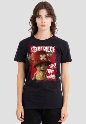 Black cotton t-shirt featuring a graphic print of a cartoon character with a red hat and antlers, surrounded by stylized text on a red background.