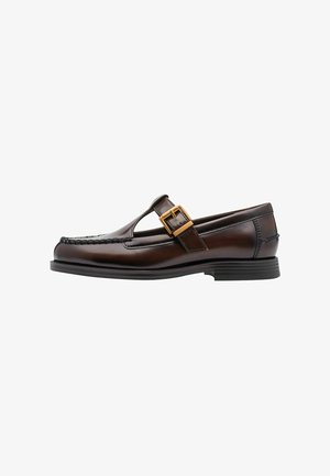 Brown leather loafers with a T-bar design, featuring a gold buckle accent, stitched details, and a flat rubber sole.
