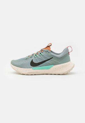 Jasnoniebieski but do biegania Nike z czarnym logo, pomarańczowym językiem, miętowozielonymi akcentami, białą nakrapianą podeszwą i czerwoną pętelką na pięcie.